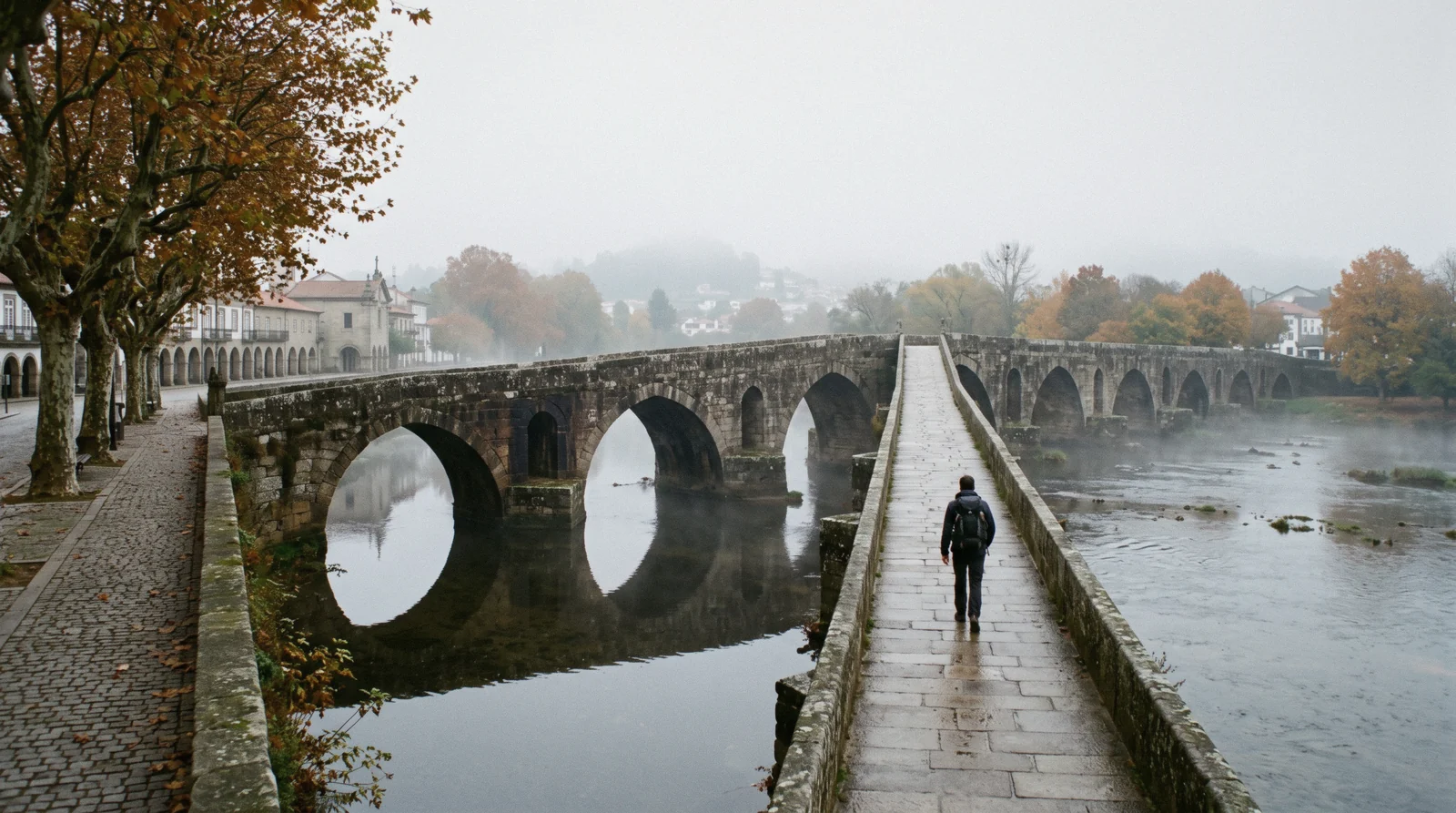 The long medieval bridge and its stone arches crossing the river Lima at Ponte de Lima under early light
