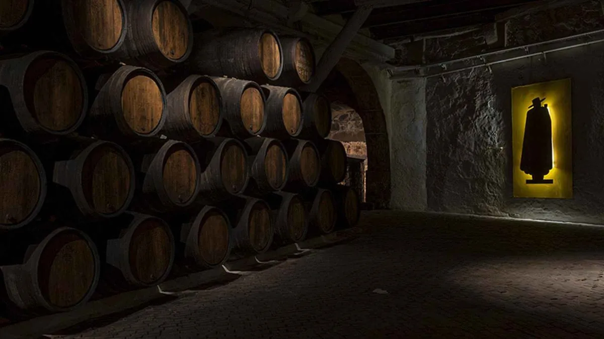 Stacked barrels in the dim Sandeman cellar in Porto